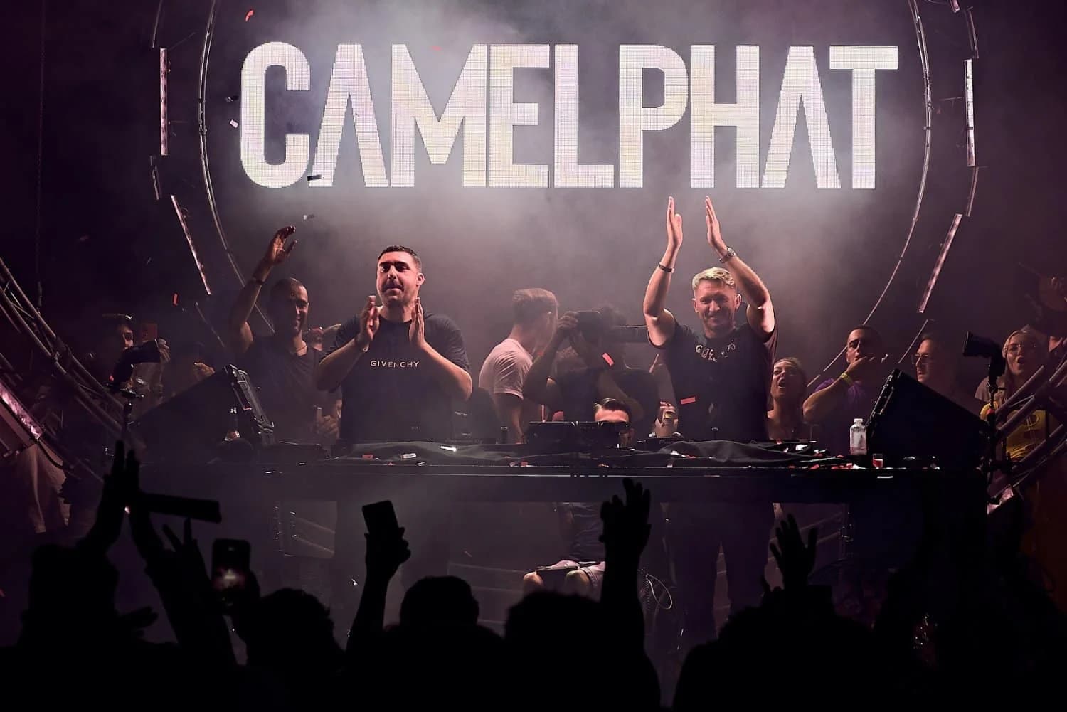 A DJ duo performs on stage with a large "CAMELPHAT" sign in the background, surrounded by a lively crowd.