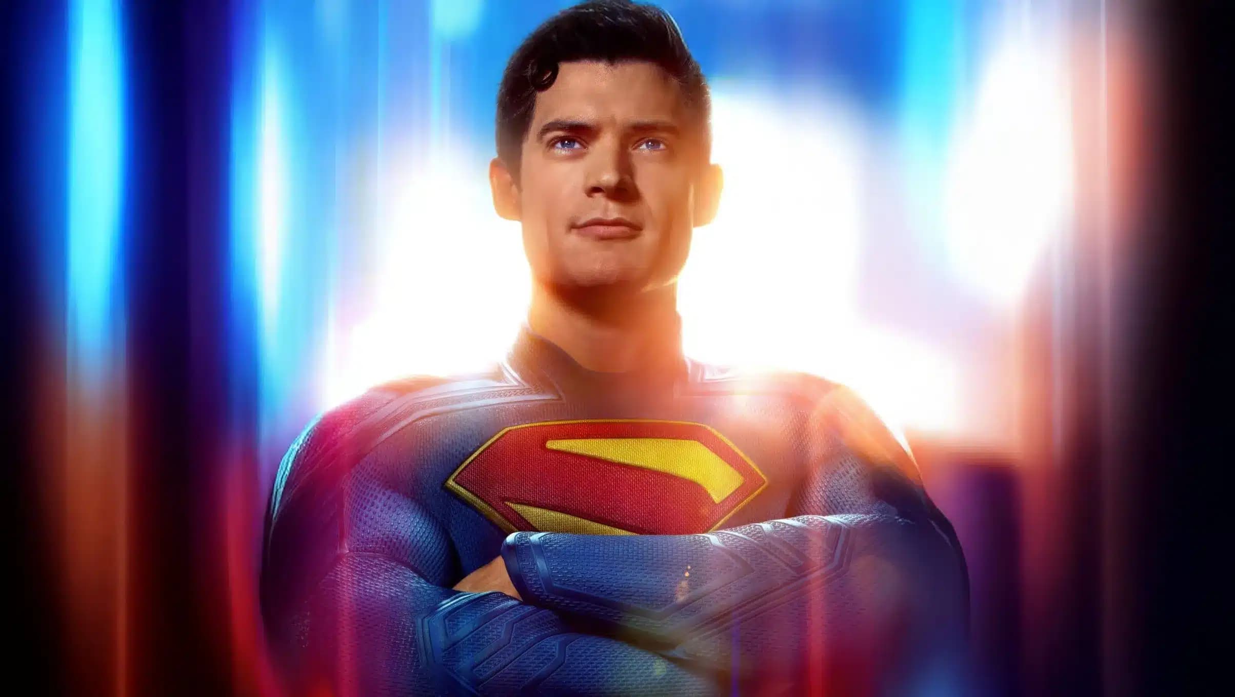 A superhero in a blue costume with a prominent red and yellow 'S' emblem on the chest, confidently standing with arms crossed against a bright, colorful background that suggests a strong, uplifting presence.